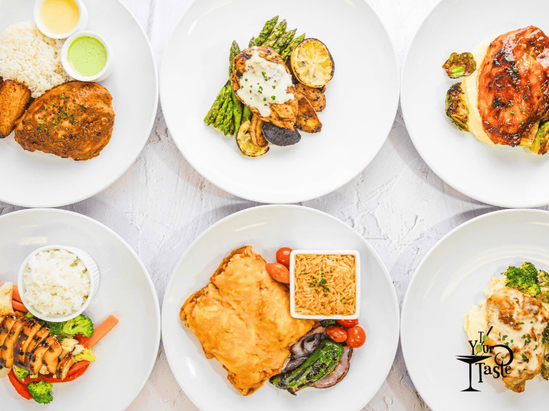 Multiple plates of food on white plates lined up neatly in two rows. A variety of proteins and veg